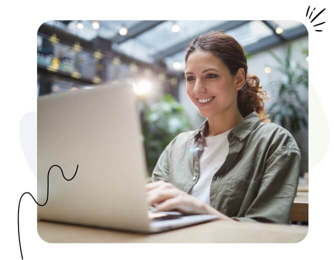 Eine glückliche Frau schaut auf ihren Laptop.