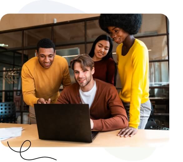 Eine vielfältigen Gruppe von Fachleuten, die in einer modernen Büroumgebung an einem Laptop zusammenarbeitet.